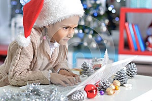 Little girl in Santa hat with laptop