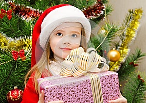 Little girl in santa hat with present have a christmas