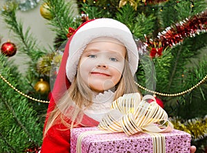 Little girl in santa hat with present have a christmas