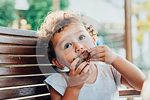Little girl savors a cake with a funny face photo