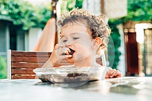 Little girl savors a cake with a funny face photo