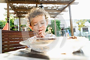 Little girl savors a cake with a funny face photo