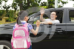 Little girl say good bye with father