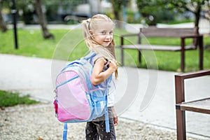 Little girl with a school backpack. The concept of school, study, education, friendship, childhood.