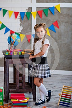 Little girl in a school uniform sits with a globe