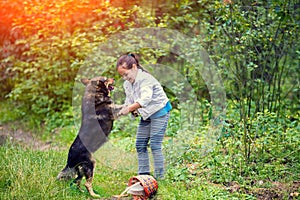 Little girl schooling dog in the forest