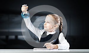 Little girl scientist examining test tube