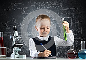 Little girl scientist examining test tube