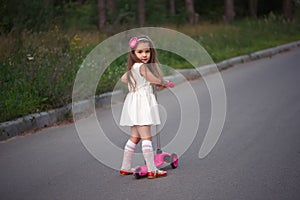Little girl with scooter on the road