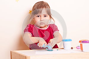 Little girl sculping with plasticine