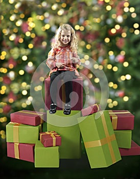 Little girl seated on christmas presents