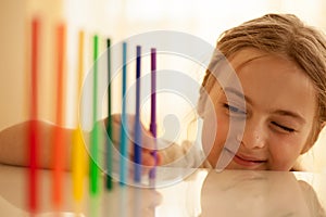 Little girl sets colorful felt pens in a row