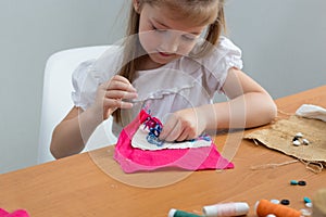little girl sewing things by herself