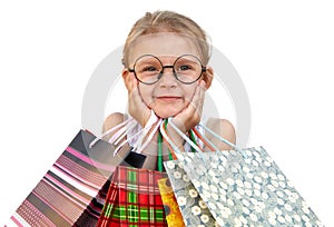 Little girl with shopping bags on white background