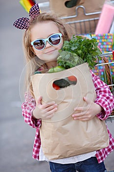 Little girl with shopping cart with products