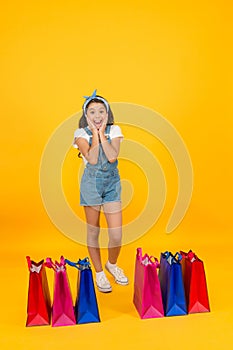 Little girl with shopping packages. Happy child with bags. Small child in summer style. Seasonal sales. Happiness of