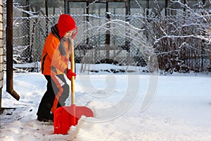 Little girl shoveling snow with shovel