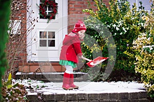 Little girl shoveling snow in winter