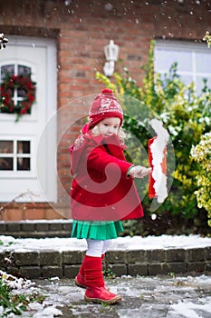 Little girl shoveling snow in winter