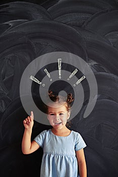 Little girl showing the concept of attentiveness with drawn chalk exclamation marks