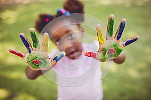 Little girl showing her painted hands to the camera