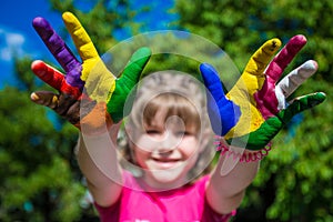 Little girl showing painted hands, focus on hands. Hand prints