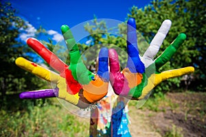 Little girl showing painted hands, focus on hands. Hand prints