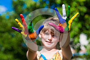 Little girl showing painted hands, focus on hands. Hand prints