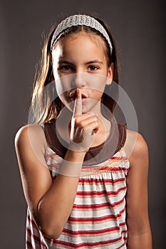 Little girl showing silence gesture