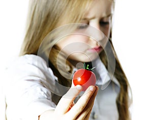 Little girl showing small red tomato