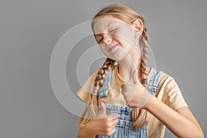 A little girl shows the ok sign with her hand