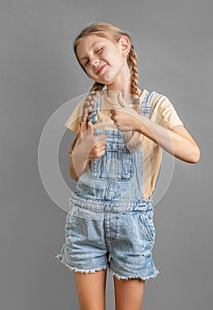 A little girl shows the ok sign with her hand