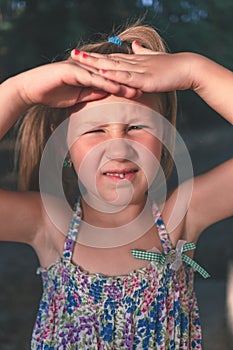 A little girl shows a wobbly baby tooth in her mouth