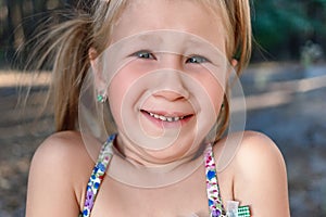 A little girl shows a wobbly baby tooth in her mouth