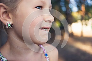 A little girl shows a wobbly baby tooth in her mouth