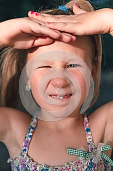 A little girl shows a wobbly baby tooth in her mouth