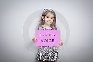 Little girl with sign hear our voice