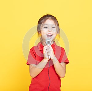 little girl singing on yellow background