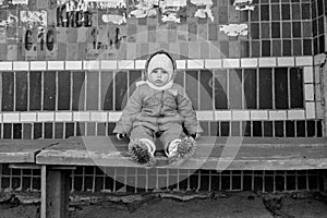 Little girl sit on bench on bus stop