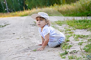 little girl sit in sand in counrtyside