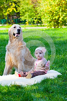 Little girl sits near a big dog