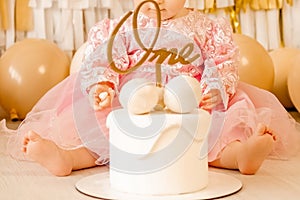 A little girl sits at the table and eats on her own. child holding a saucer with a cup