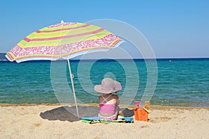 Little girl sitting on beach