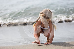 Little girl sitting on the beach