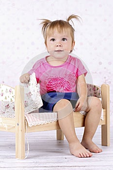 Little girl sitting on the bed