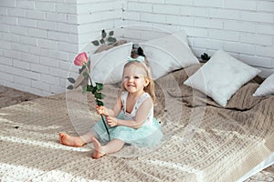 A little girl is sitting on the bed