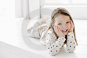 A little girl sitting on a bed