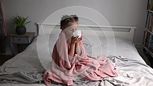 Little girl sitting in bed being cold drinking tea to warm. Sick Little Girl, health-care concept