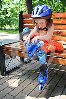 Little girl sitting on bench and removing roller