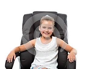 Little girl sitting in big armchair